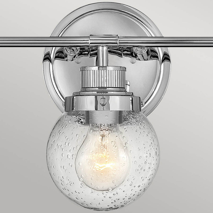 Gros plan sur la fixation murale ronde et le support métallique chromé du luminaire