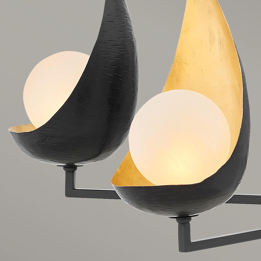 Gros plan des coupelles noires martelées, intérieur doré et globes d'albâtre