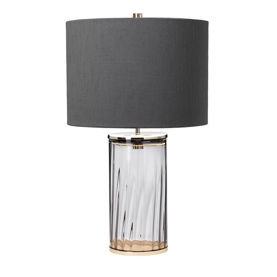 Vue de trois quarts de la lampe, montrant le socle métallique nickel et le verre transparent
