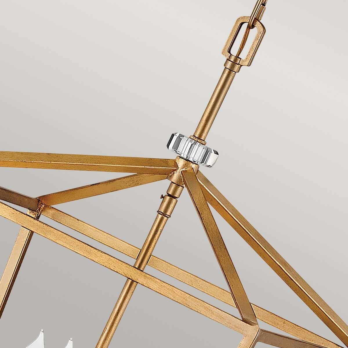 Gros plan sur la tige centrale et le collier en cristal du luminaire