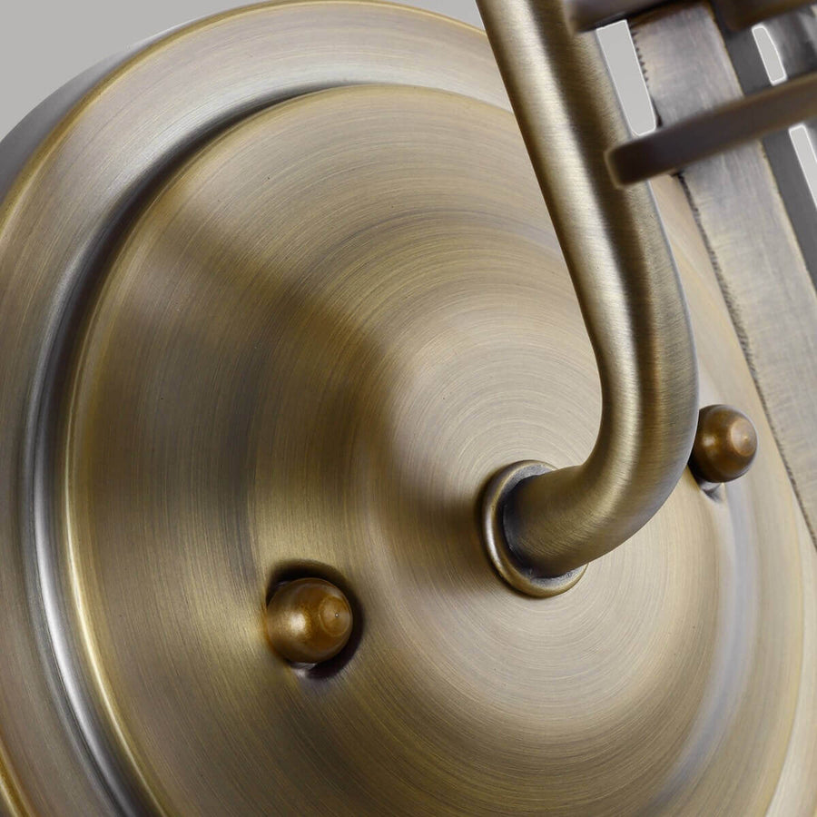 Détail de la platine ronde en laiton brossé et de ses vis de fixation.