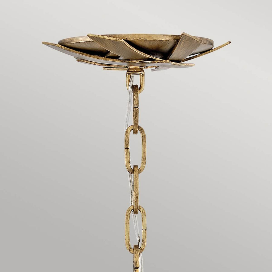 Détail du support plafond doré et chaîne de suspension avec câble transparent.