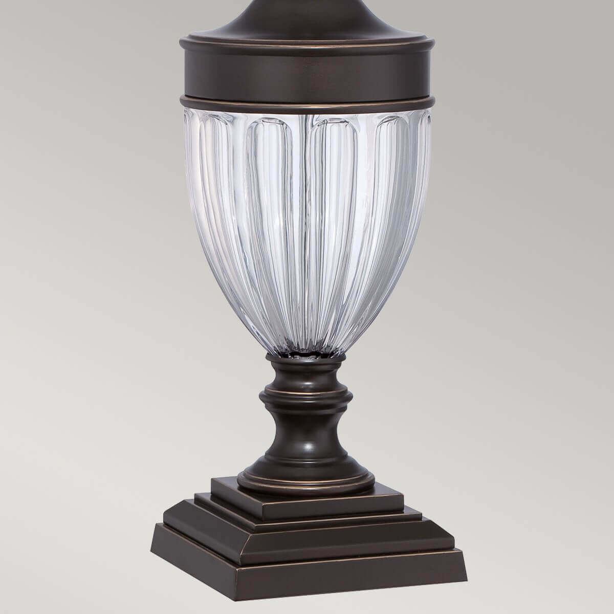 Vue rapprochée du pied en verre godronné et de la base bronze.