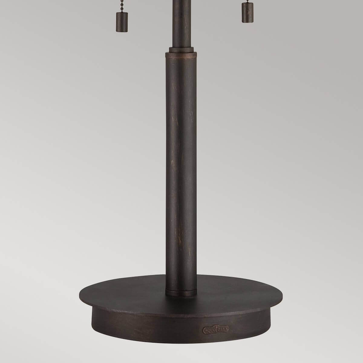 Détail de la base ronde et du pied cylindrique en métal bronze foncé