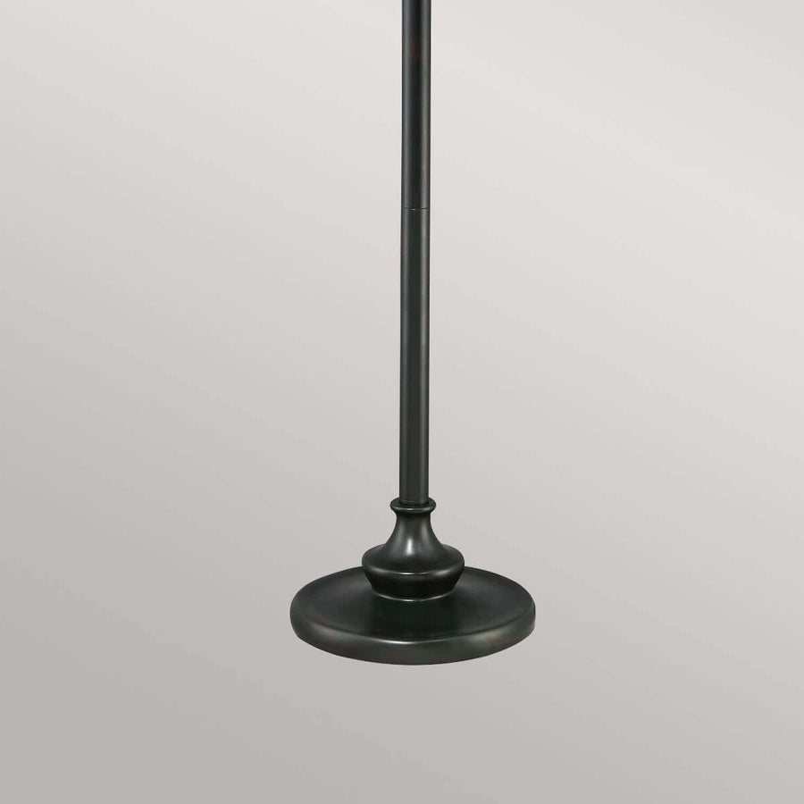 Détail de la base circulaire et du pied cylindrique en métal bronze foncé