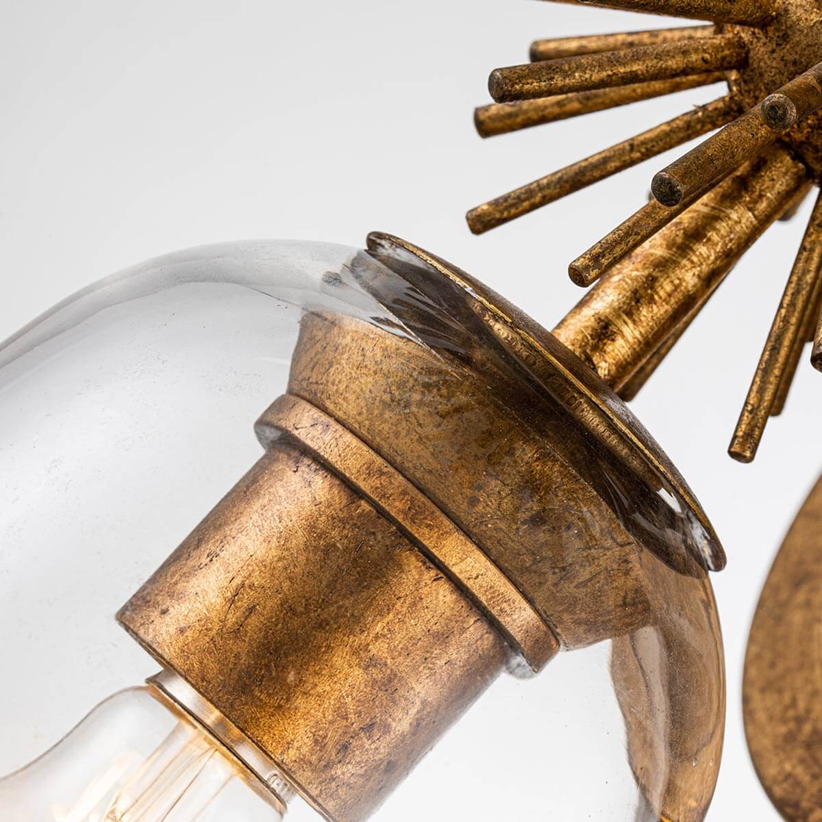 Détail du culot doré et du verre fixé sous l'étoile rayonnante