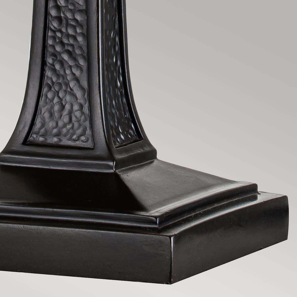 Détail de la base carrée et du décor martelé du fût bronze