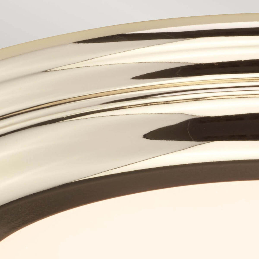 Détail du reflet miroir sur la bague en métal poli et bord du verre.