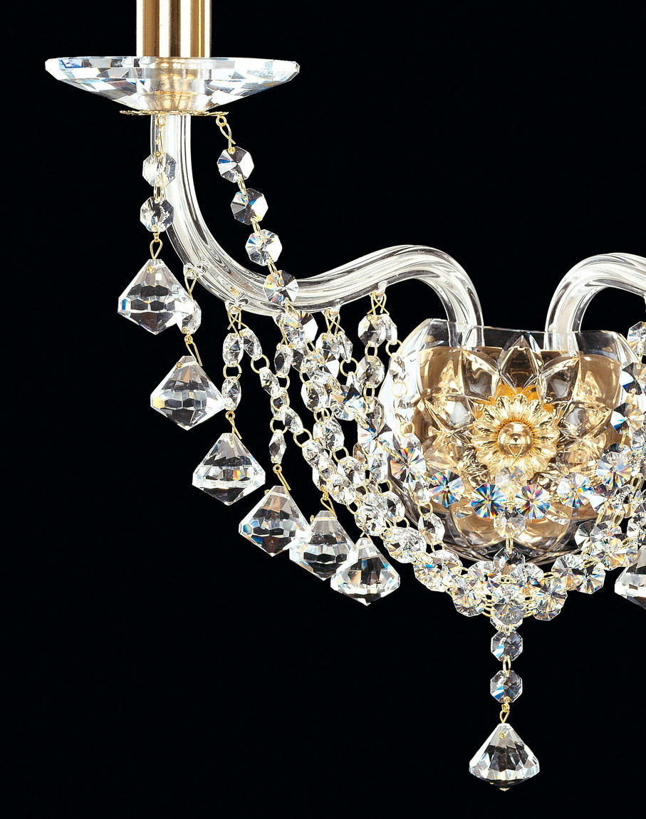 Gros plan sur les pendeloques de cristal taillé et la rosace fleur dorée du luminaire