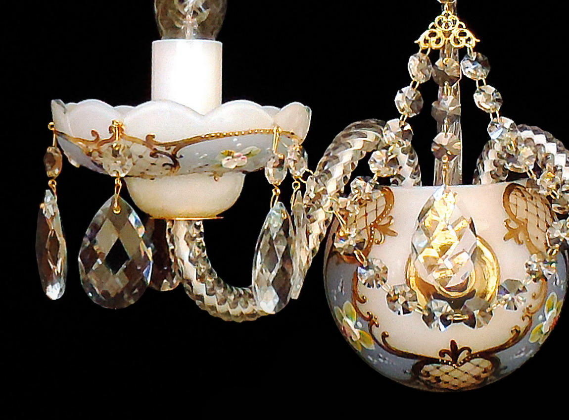 Détail d'une coupelle en verre blanc, pampilles de cristal et bras recourbé doré