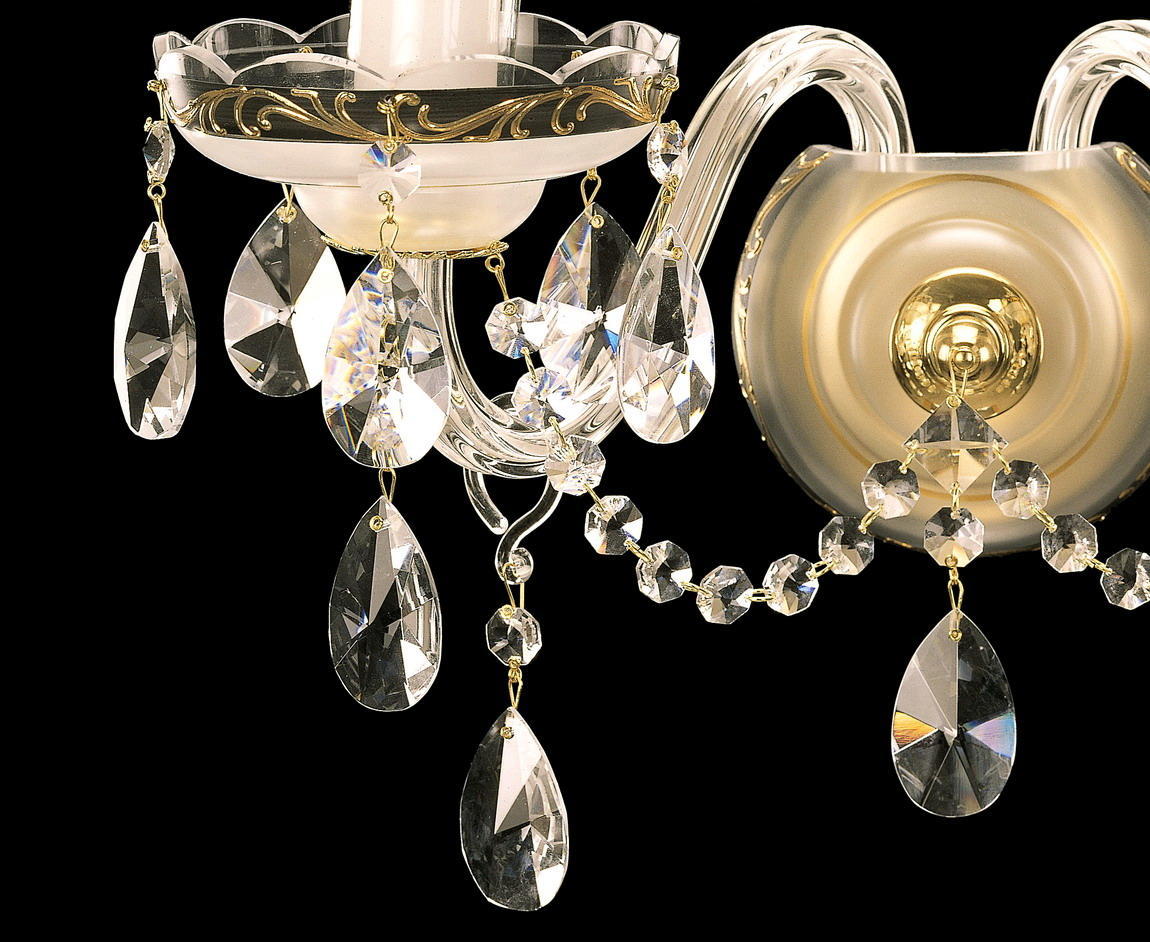 Gros plan sur la coupelle festonnée dorée, les chaînettes et pendentifs de cristal taillé