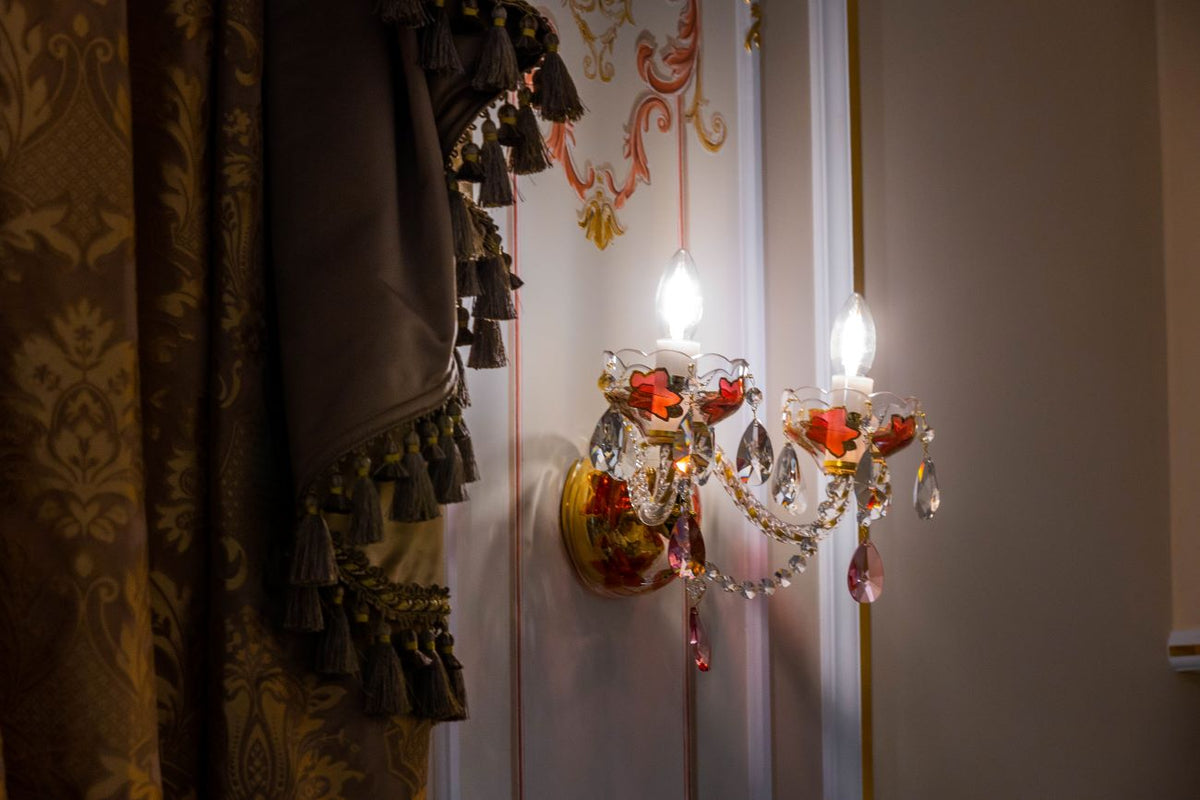 Applique en situation près d'un rideau à pompons, ambiance feutrée