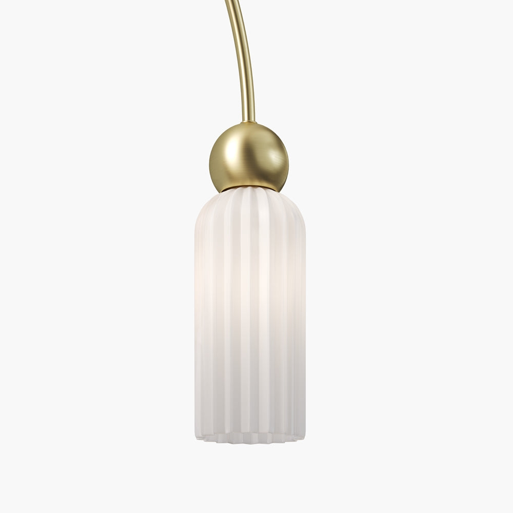 Gros plan sur un abat-jour cylindrique en verre cannelé et sa sphère dorée.
