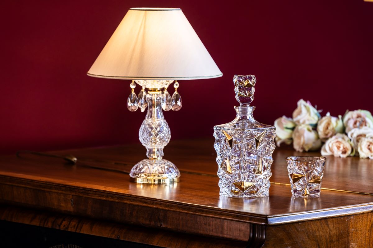 Mise en ambiance sur buffet en bois, carafe en cristal et roses claires