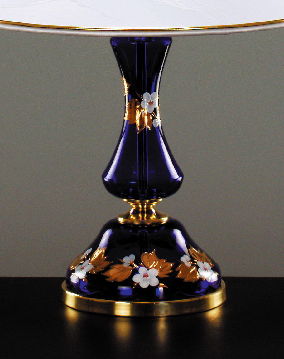 Détail du pied en verre bleu nuit orné de fleurs blanches et feuilles dorées