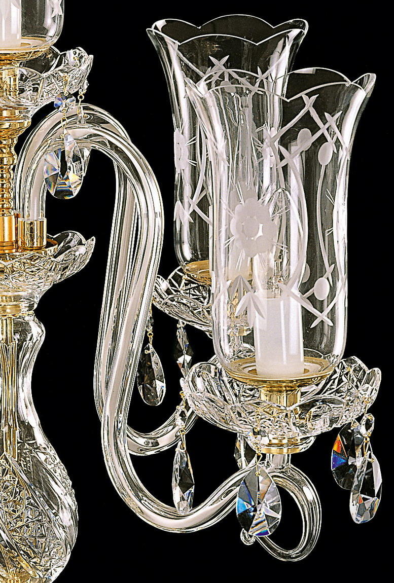 Détail d'un bras recourbé en verre ciselé avec pampilles et douille dorée.