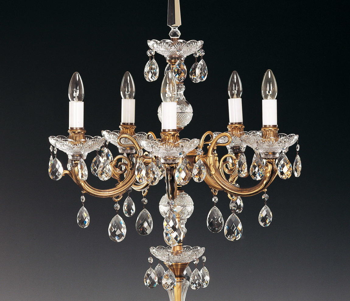 Détail rapproché des bras dorés, bobèches ciselées et pendeloques de cristal taillé