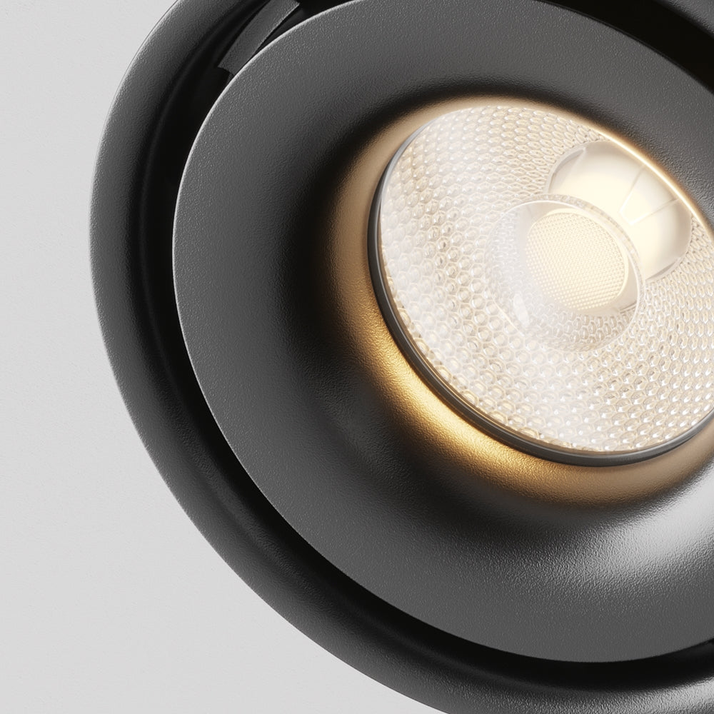 Gros plan sur la lentille LED texturée et l'intérieur doré du projecteur.
