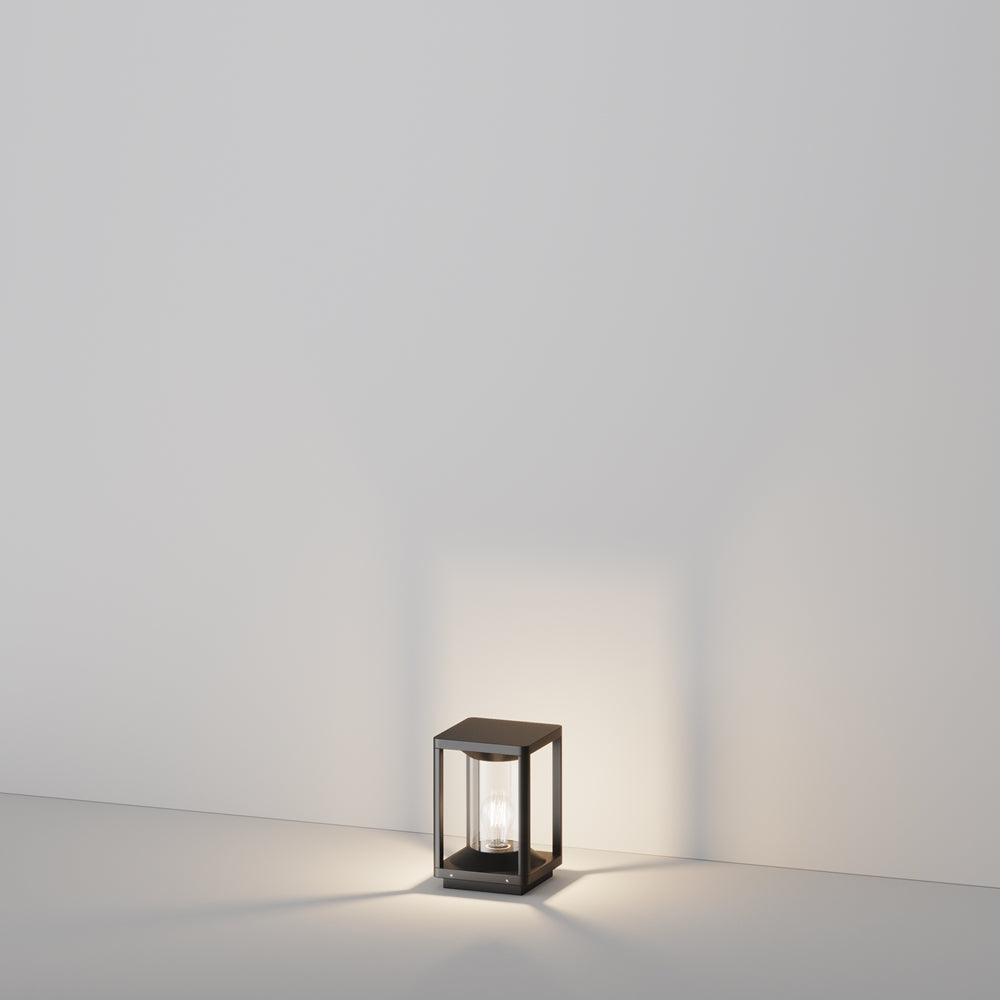 Mise en ambiance de l'applique posée au sol, halo lumineux doux.