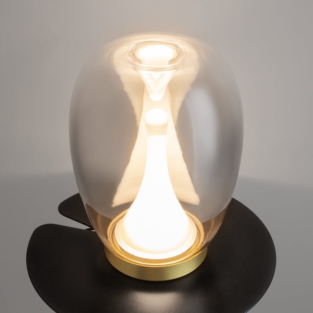 Vue trois quarts de la lampe allumée, reflets brillants sur le verre extérieur