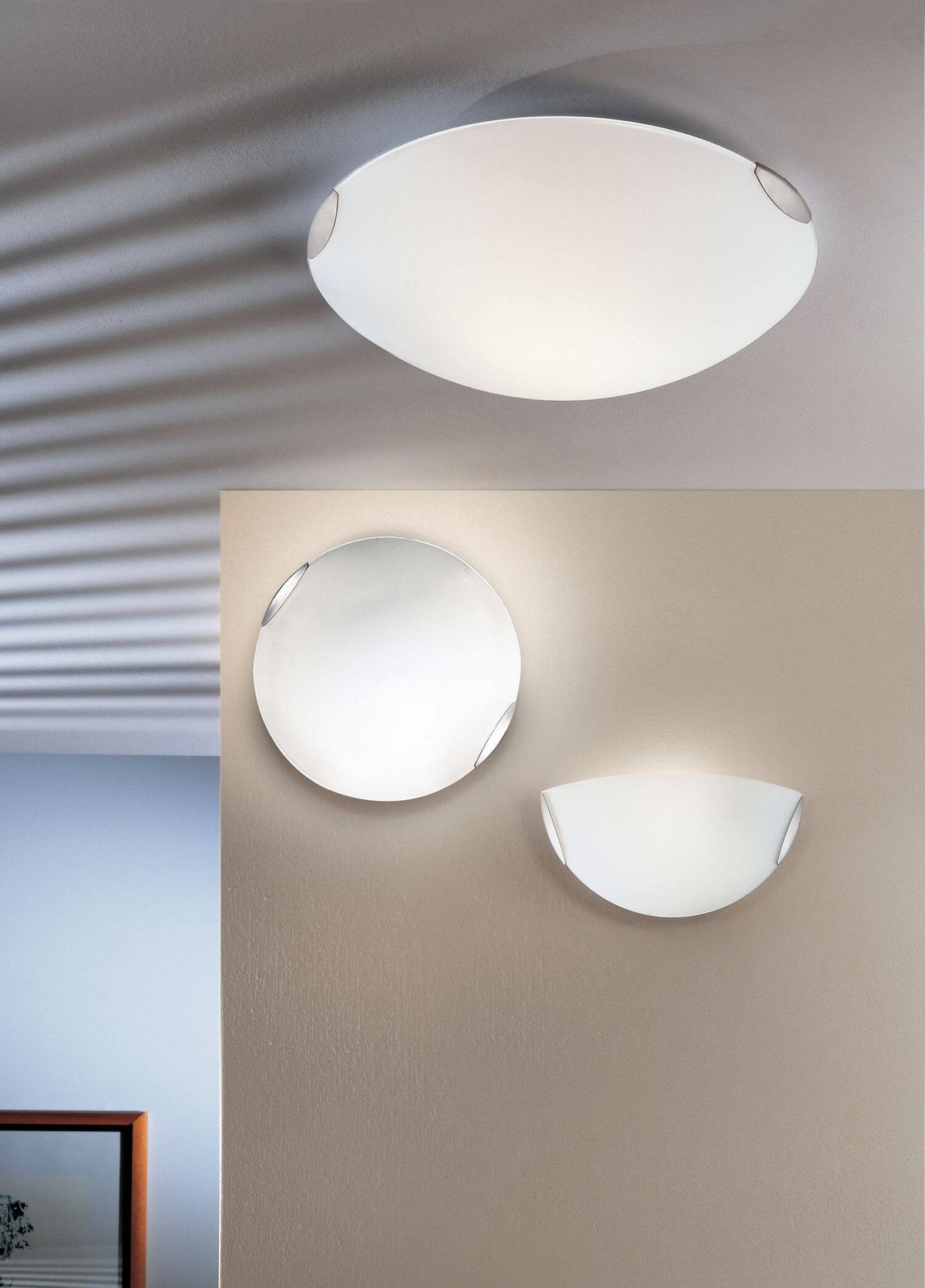 Mise en ambiance montrant plafonnier et deux appliques murales blanches sur mur beige