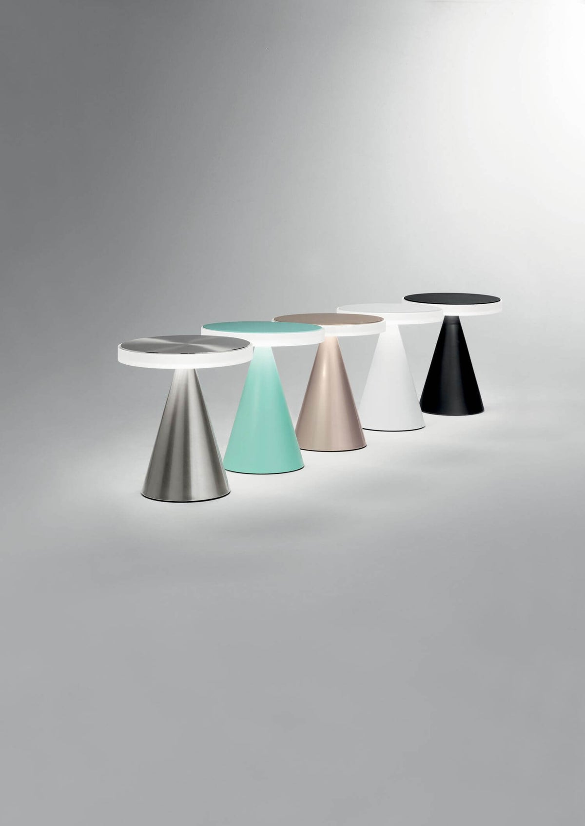 Cinq lampes à poser alignées, déclinaisons de coloris, dont le modèle vert d'eau.