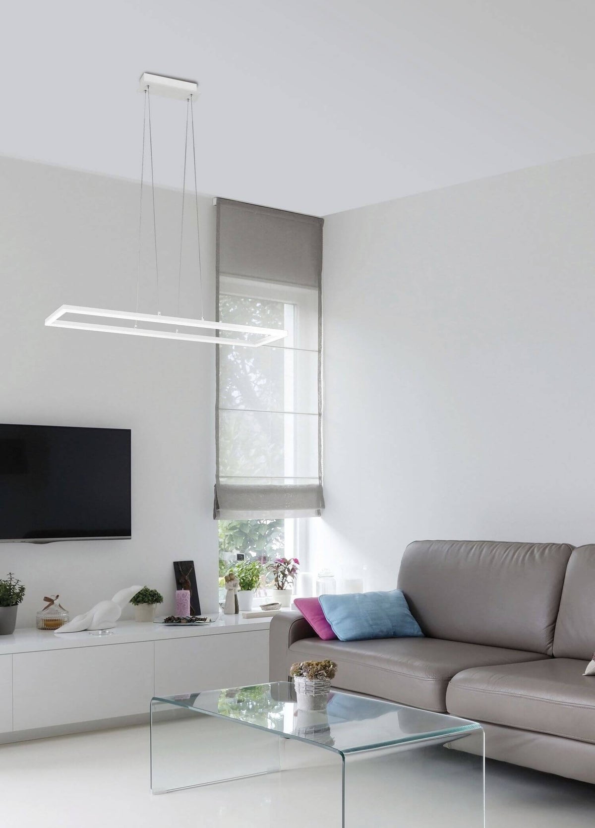 Mise en ambiance du luminaire suspendu au-dessus d'un salon minimaliste avec canapé gris