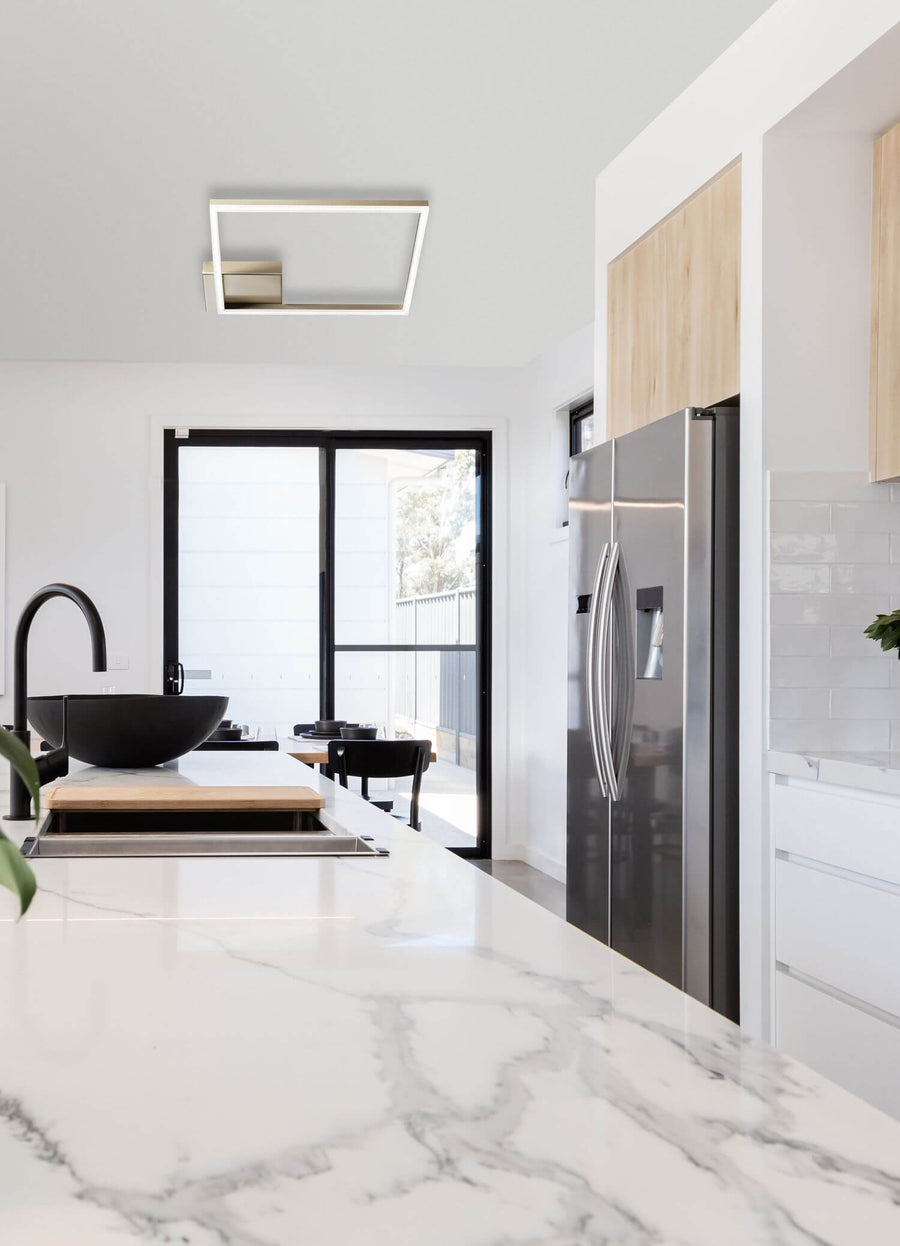 Vue en situation dans une cuisine blanche, luminaire fixé au plafond au-dessus de l'îlot
