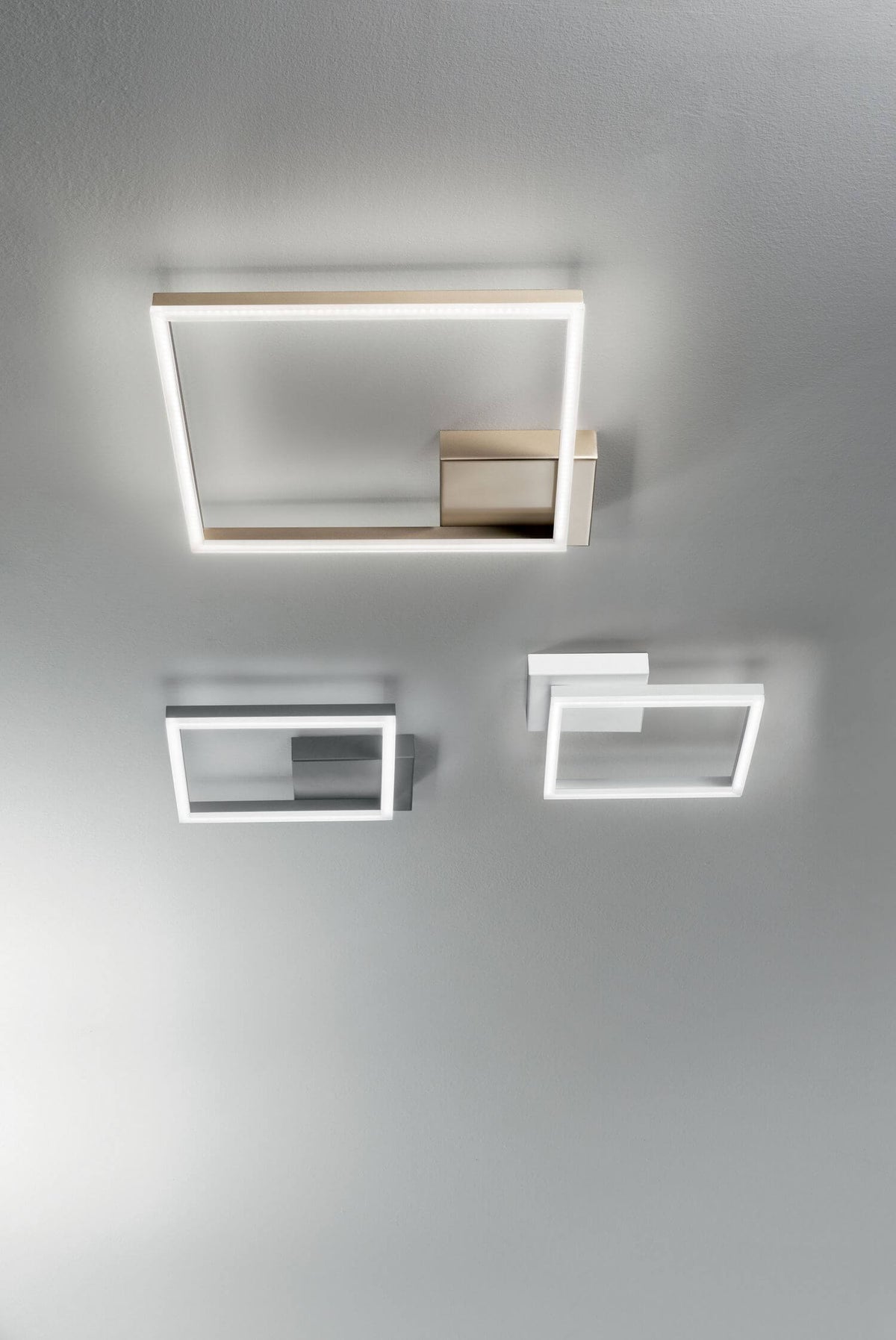 Trois tailles de plafonniers rectangulaires alignés au plafond, finitions dorée, acier et blanche