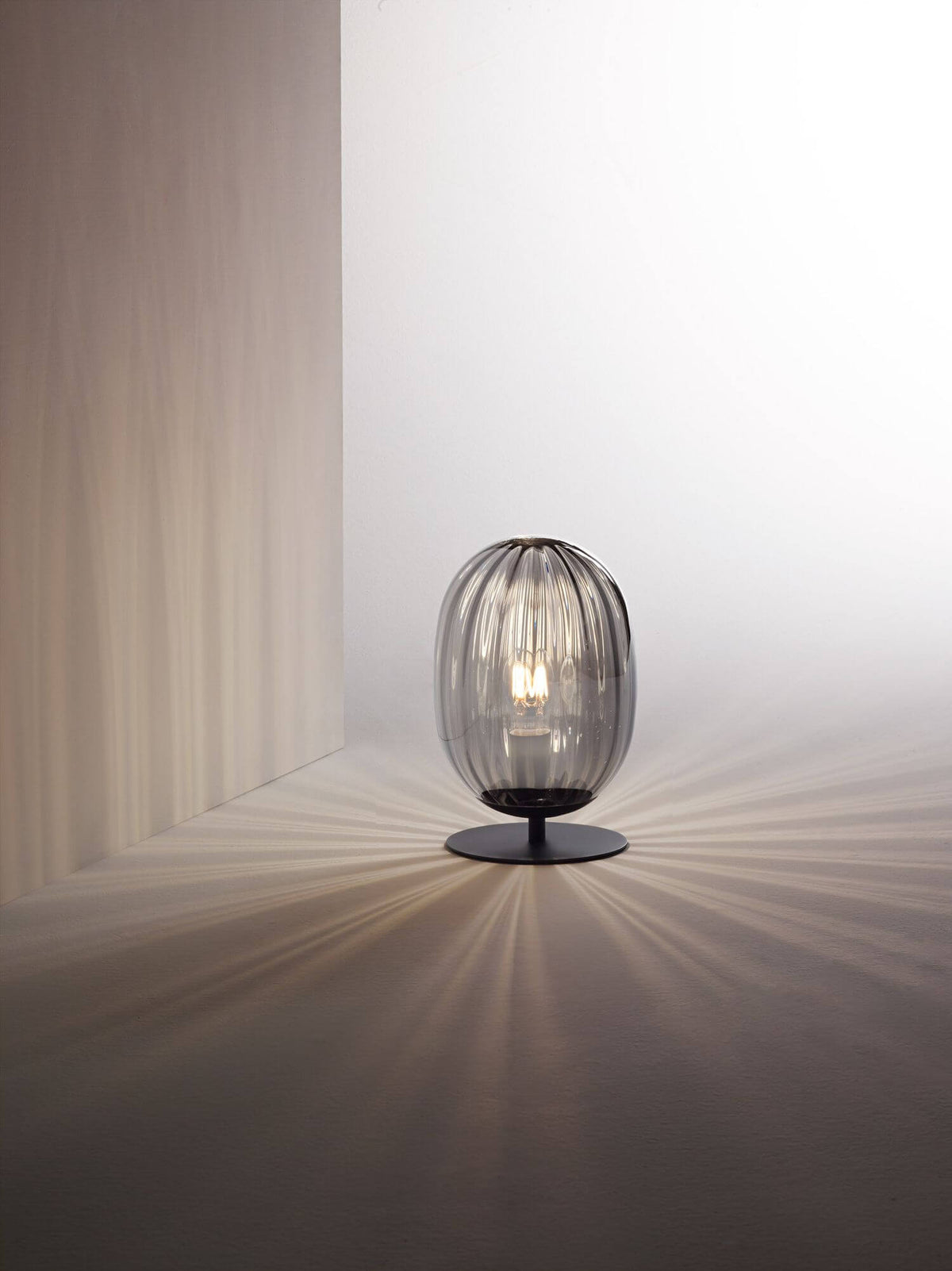 Mise en ambiance de la lampe allumée, motif d'ombres rayonnantes projeté au sol