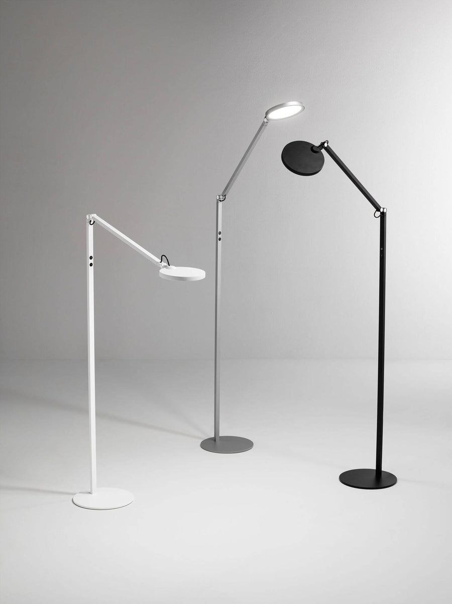 Trois lampes identiques déclinées en blanc, gris et noir, alignées sur fond clair