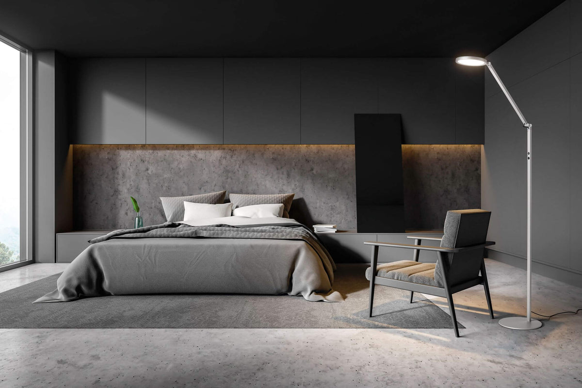 Mise en ambiance de la lampe allumée près d'un fauteuil dans une chambre sombre