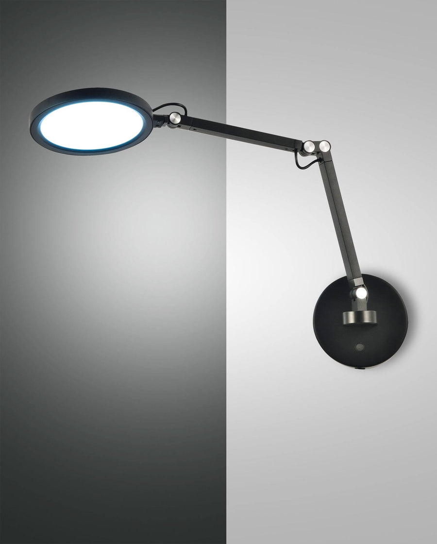 Vue de profil du luminaire mural noir, bras articulé et tête ronde allumée