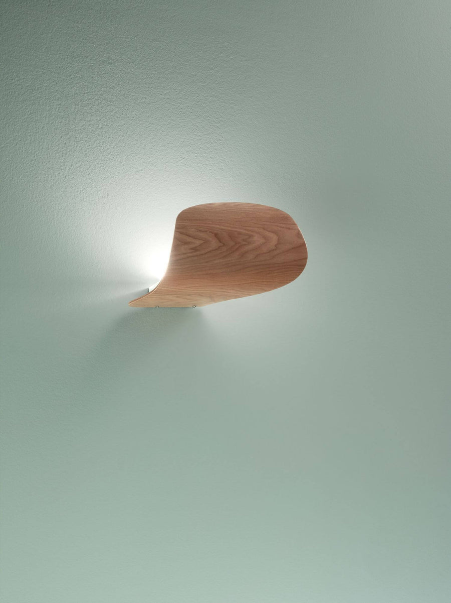 Vue de profil de l'applique fixée au mur vert pâle, halo lumineux vers le haut
