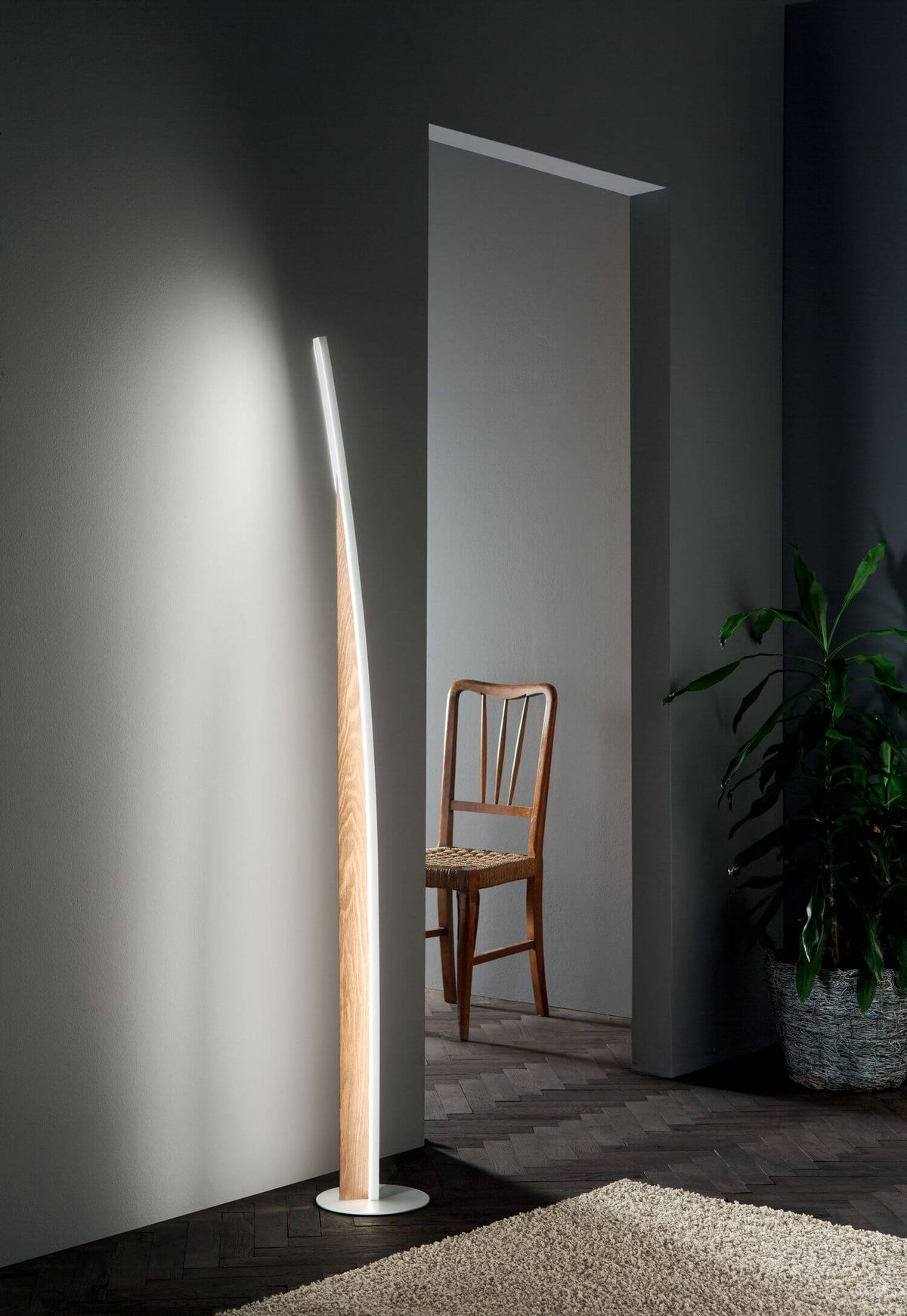 Mise en ambiance du lampadaire dans un couloir, halo lumineux projeté sur le mur gris