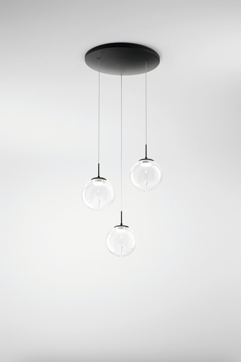 Vue d'ensemble du luminaire suspendu avec trois boules en verre clair et câbles fins.