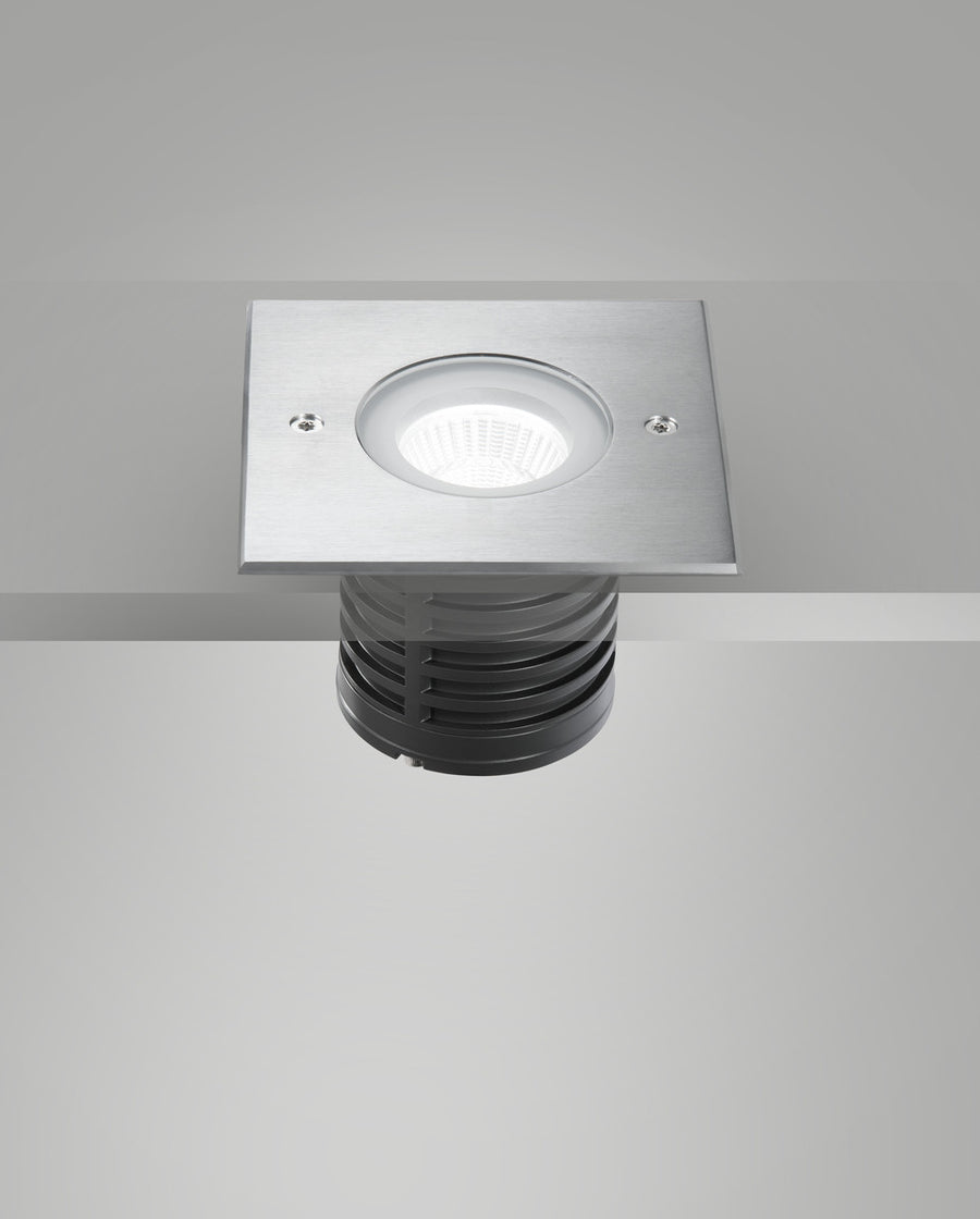 Luminaire encastré dans une surface grise, vue par-dessous avec optique allumée