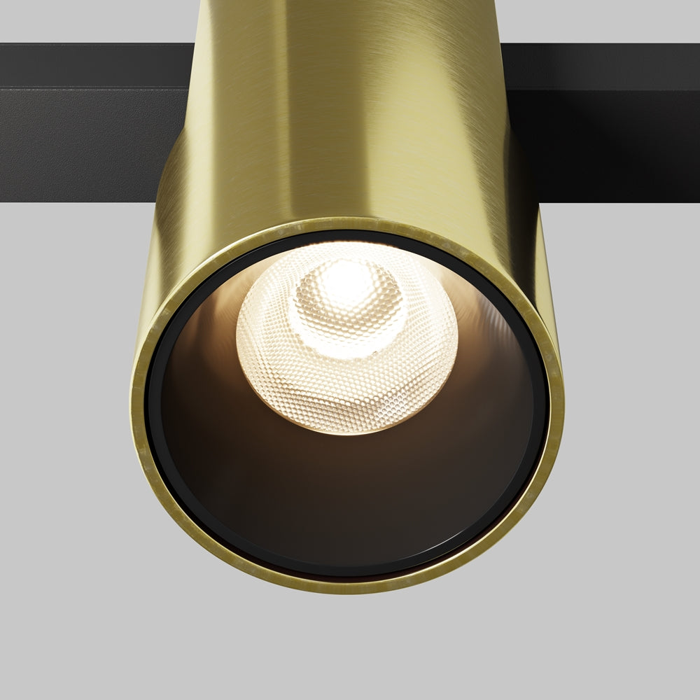 Détail rapproché de la lentille LED et de la collerette dorée brossée.