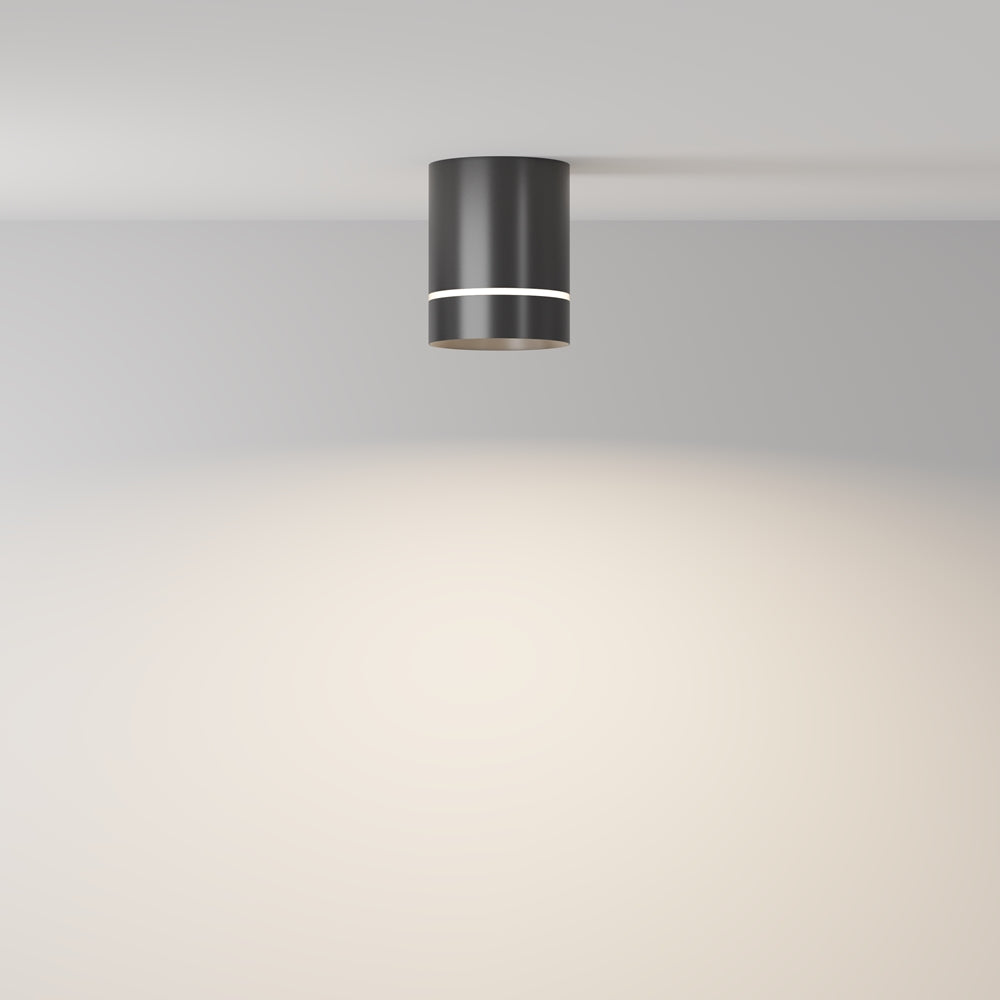 Mise en ambiance : le cylindre noir diffuse une lumière douce sur le mur