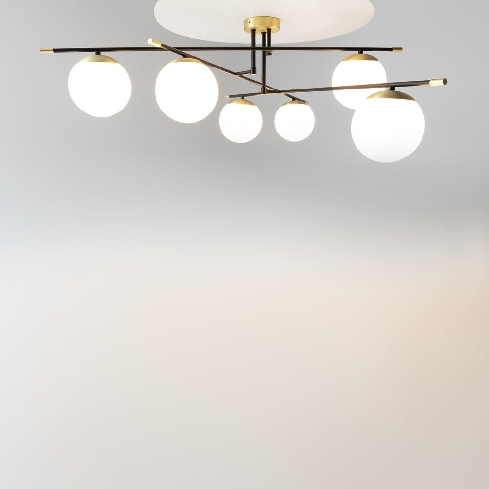 Vue plongeante du luminaire allumé sous un plafond clair, diffusant une lumière chaude.