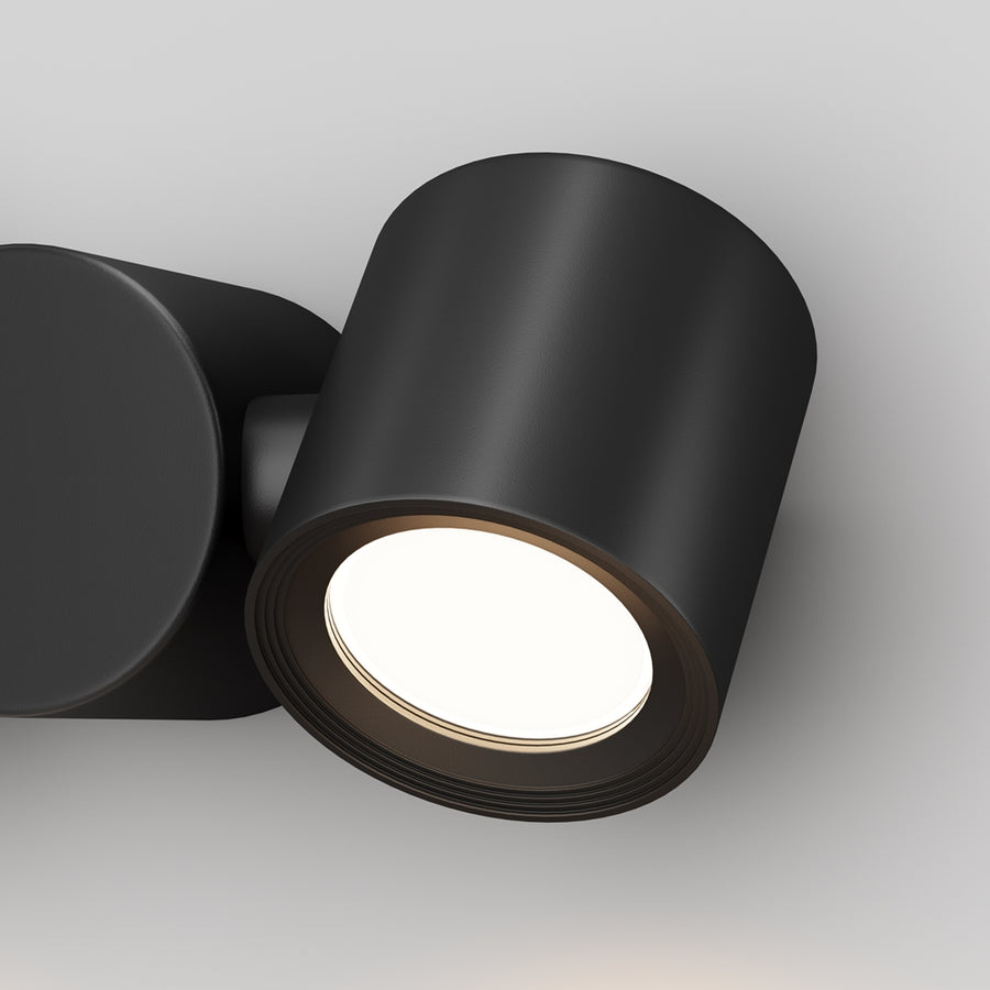 Gros plan sur un spot cylindrique noir et sa lentille lumineuse