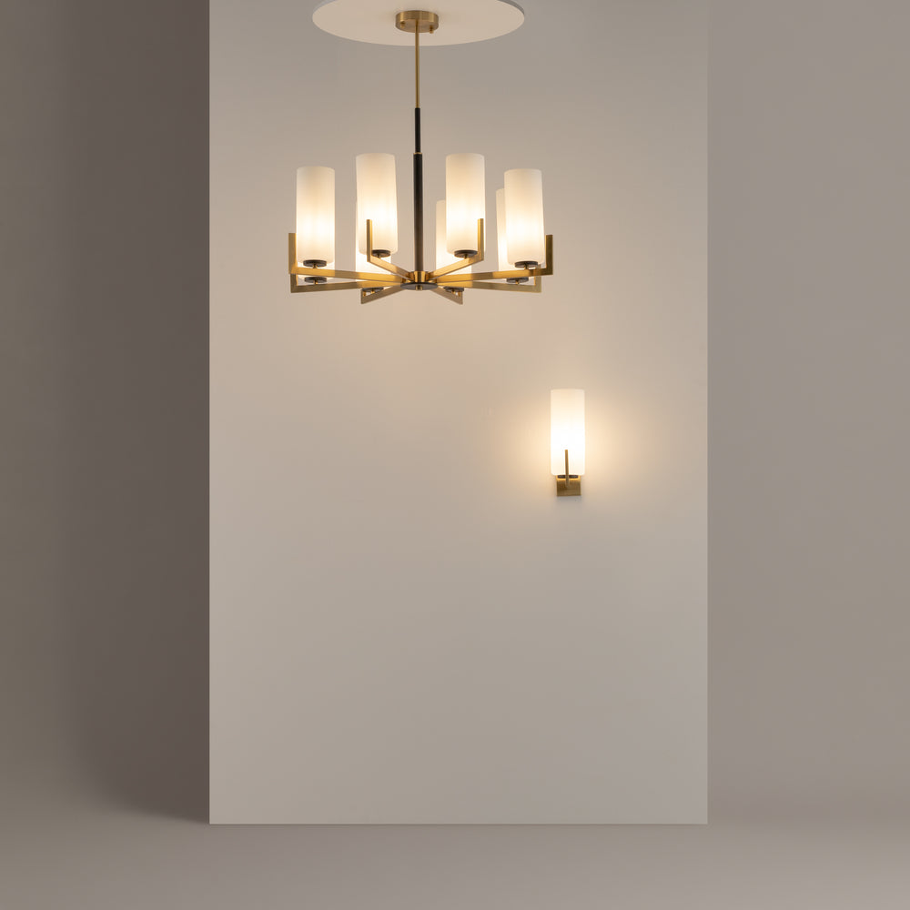 Suspension et applique assortie éclairées dans un intérieur aux murs gris clair.