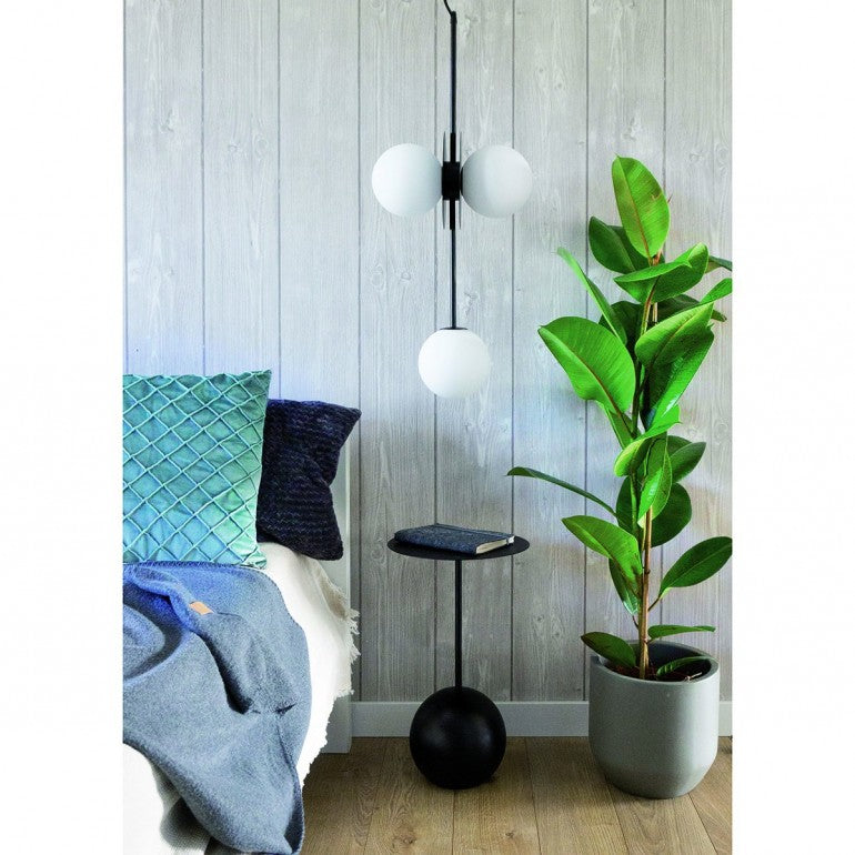 Mise en ambiance dans une chambre, suspension allumée au-dessus d'une table