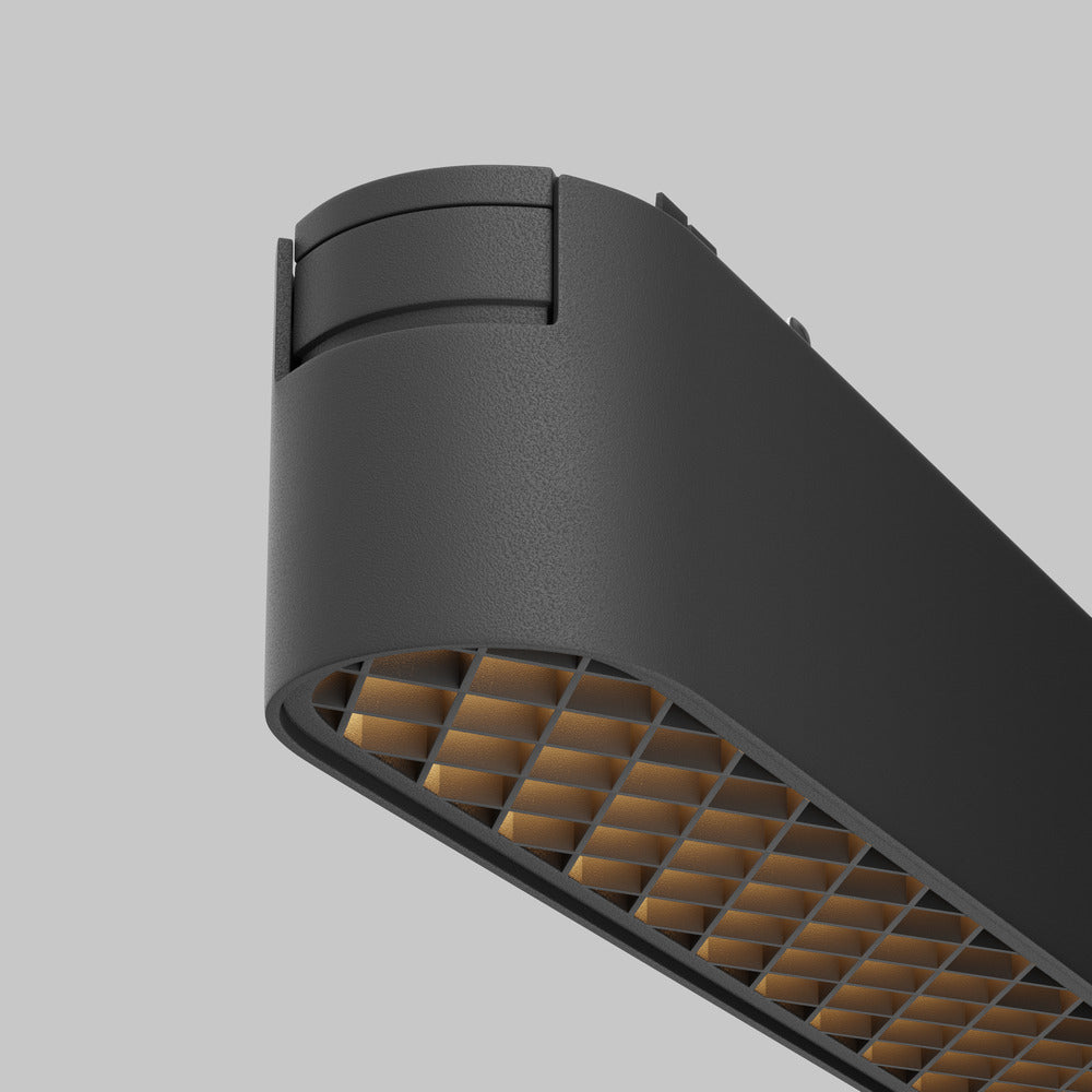 Gros plan sur le boîtier noir texturé et la grille dorée du projecteur