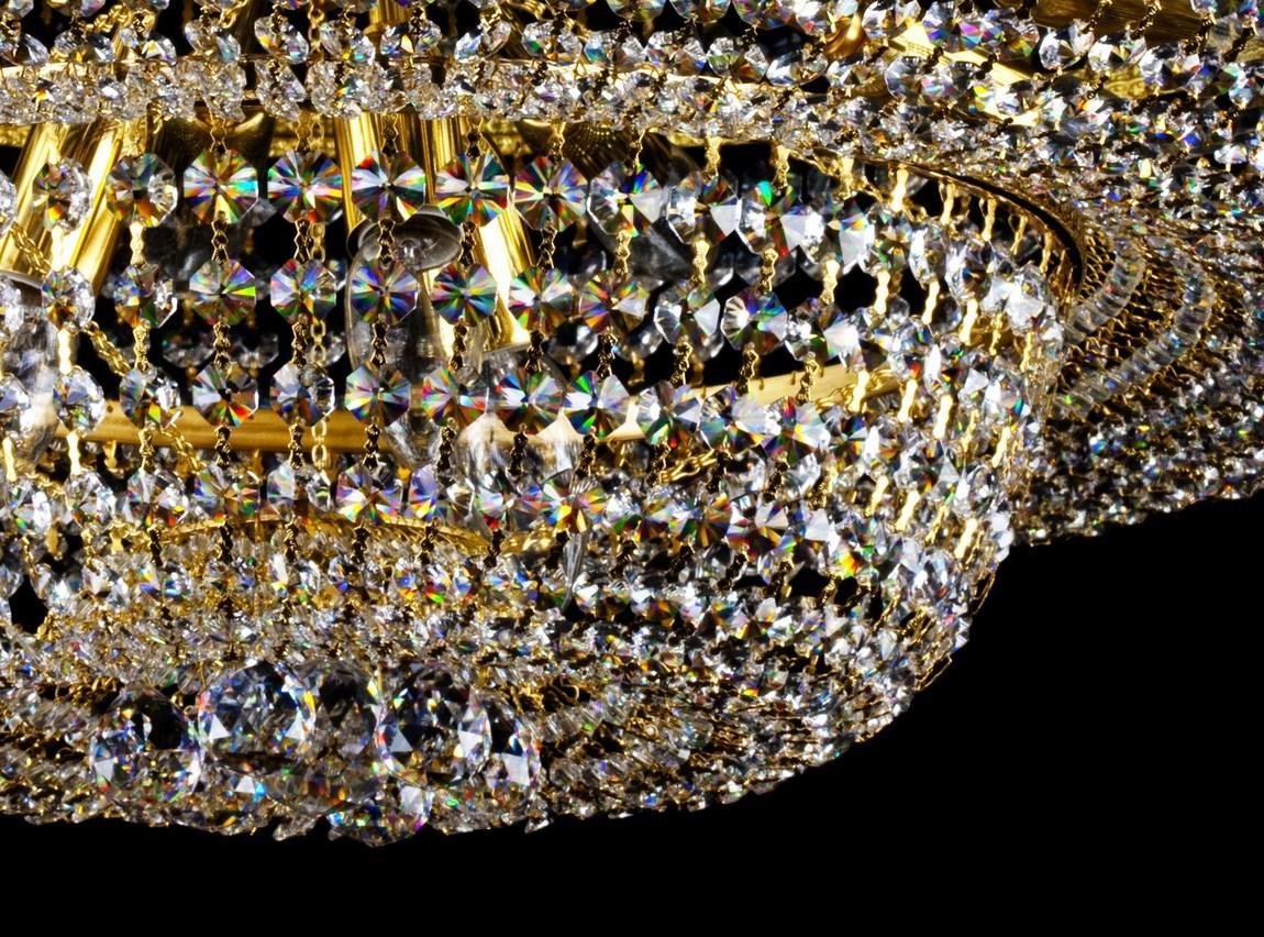 Gros plan sur les octogones de cristal irisés et les bras métalliques dorés
