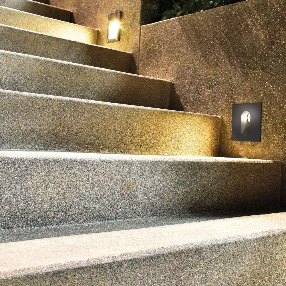 Mise en ambiance nocturne sur un mur d'escalier extérieur en pierre.