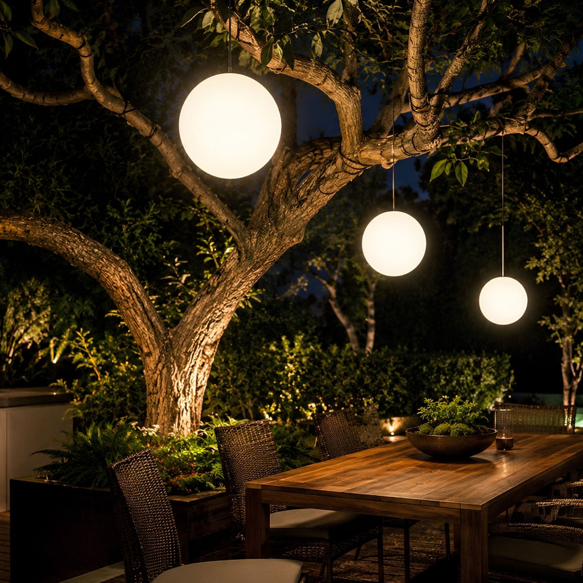 Boules lumineuses éclairant une table de jardin en bois et des fauteuils tressés