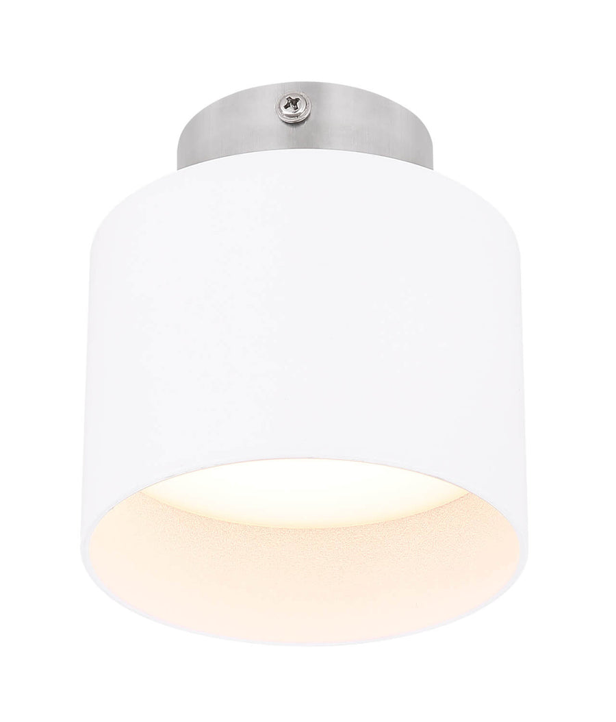 Vue du plafonnier allumé, diffusant une lumière chaude sous l'abat-jour cylindrique blanc.