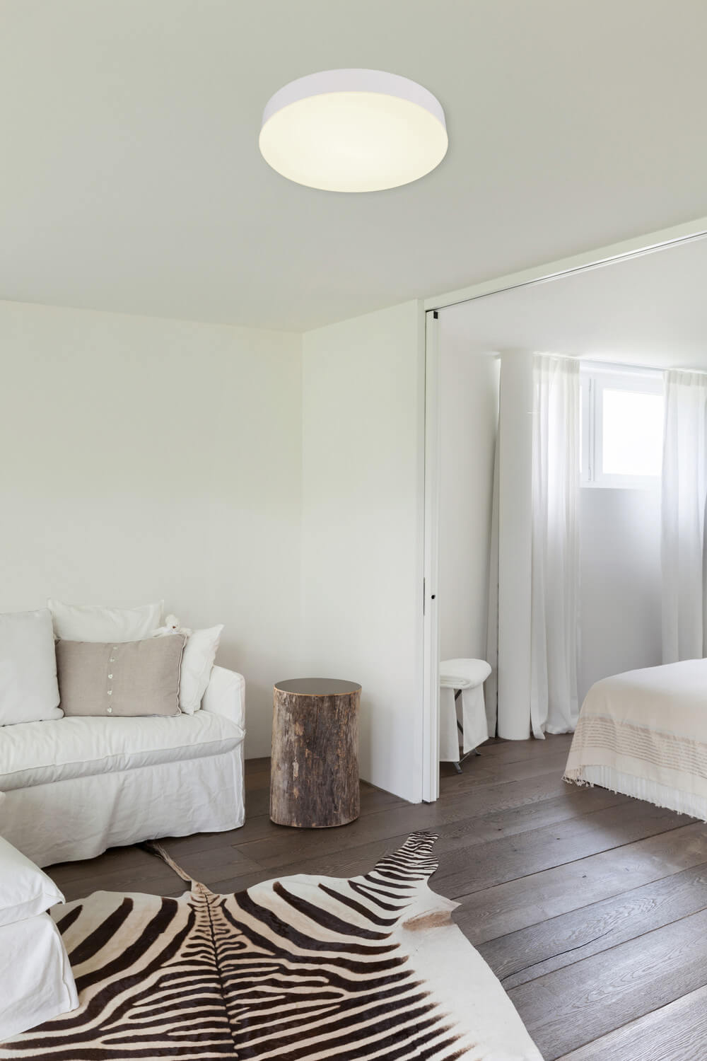Mise en ambiance dans une chambre blanche, plafonnier allumé au plafond