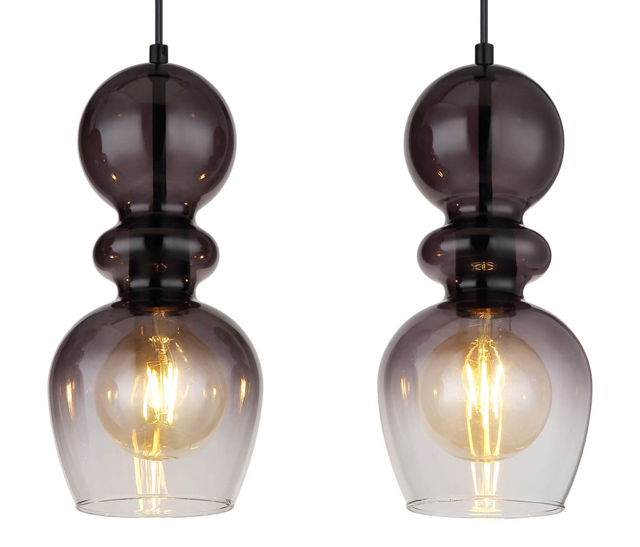 Détail rapproché de deux globes en verre fumé et ampoule filament allumée